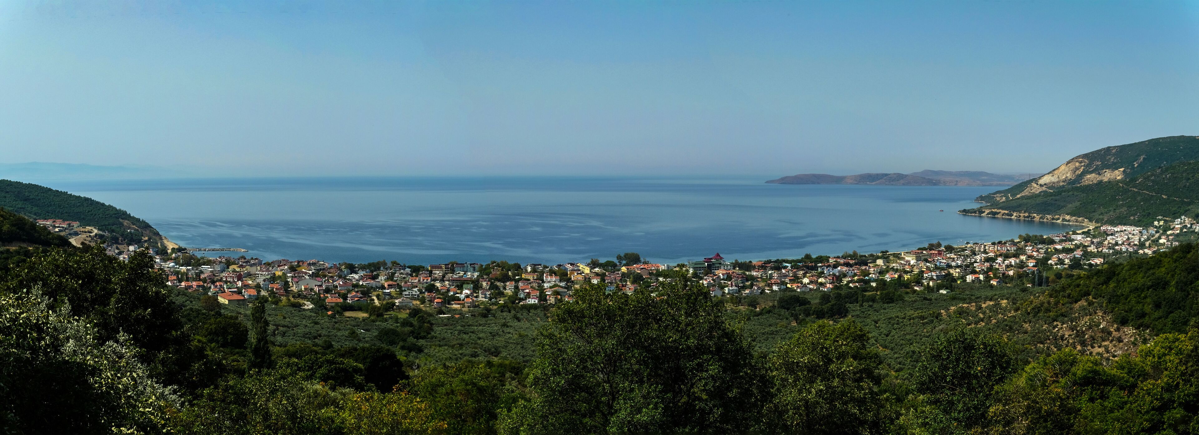 A coastal town with a view of the sea and hills.