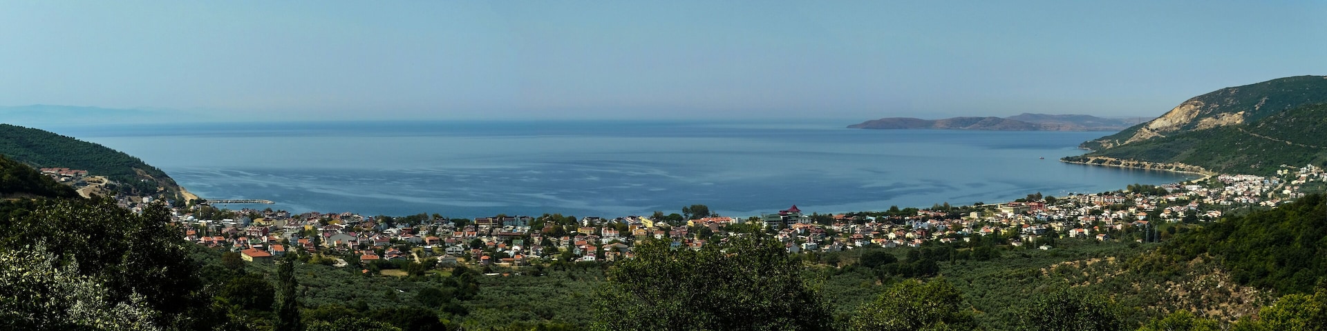 A coastal town with a view of the sea and hills.