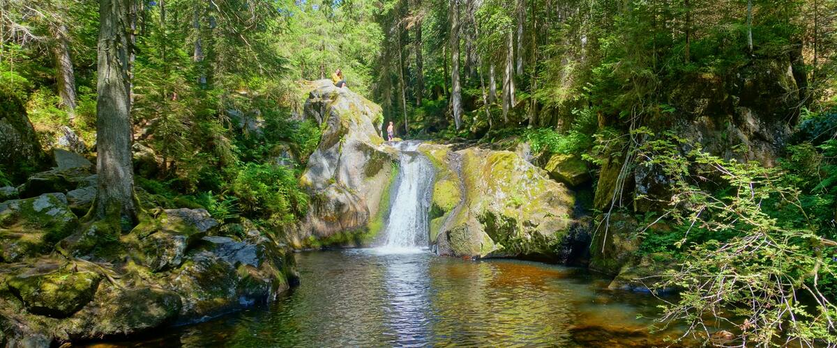 Der Wasserfall ("Krai-Woog-Gumpen") und die Gletschermühle gehören zu den schönsten, aber auch geheimnisvollsten Anziehungspunkten in der Natur des Oberen Hotzenwales. In der dichten Waldwildnis - ohne asphaltierte Straßen und von wenigen Holzwegen durchzogen - wurde die Gletschermühle erst 1952 durch Erwin Litzelmann entdeckt und frei gelegt. Namensherkunft "Krai" bedeutet: Laut sein, Schreien. Hochdeutsch verwand ist "Krähen". Hier ist aber mehr "lautes Rauschen" gemeint. Auf vielen Landkarten steht heute noch "Kleiner oder Klai-Wooggumpen": eine Umdeutung der preußischen Landvermesser die auch aus dem benachbarten "Turbenmoos" ein "Taubenmoos" machten, da sie nicht wussten, dass Torf alemannisch "Turben" heißt. "Woog" bedeutet Wasserfall. Hochdeutsch ist die "Woge"= größere Welle damit verwandt. "Gumpen" bedeutet als Verb "springen", "hüpfen" ( "ein Frosch gumpt ins Wasser"). Als Substantiv ist "Gumpen" ein Becken, sprachlich verwandt ein "Tümpel", in welches Wasser hinein fällt bzw. sich dort sammelt. Beides trifft hier zu. So wäre die Übersetzung für "Krai-Woog-Gumpen": Ein lauter (rauschender) Wasserfall, der in ein Becken spring.