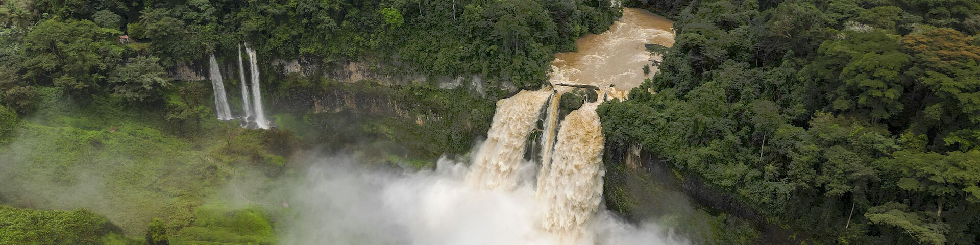 Aerial view of the cascading Ekom Nkam Falls plunge into the river amidst the lush green forest, Ekom Nkam Falls, Nkongsamba, Cameroon.
