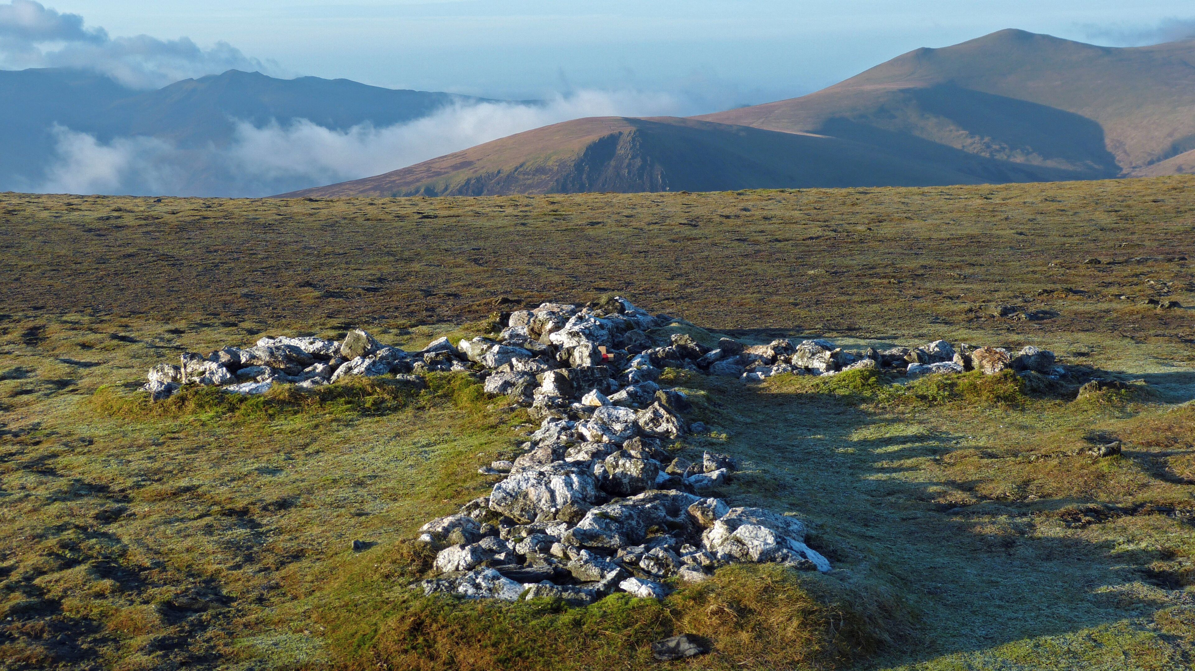 According to Wainwright this is down to a Threlkeld man, Harold Robinson, who added a lump of quartzite each time he climbed the hill.