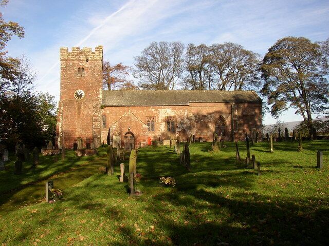St Michael's Church, Kirkby Thore The church is Grade II* listed, and was built in the 12C with later additions. The west tower has stepped buttresses and bell-openings in the Decorated style, as are the chancel and aisle windows. The embattled parapet has a 17C gabled bellcote on the east side. There is a north window set in a Norman arch. The moulded octagonal font was provided in 1688 by Thomas Machell, the rector, whose coat of arms is carved on one side. In the chancel the Wharton coat-of-arms is set into the wall. There is a blocked 14C priests' door to the right of the 19C vestry.