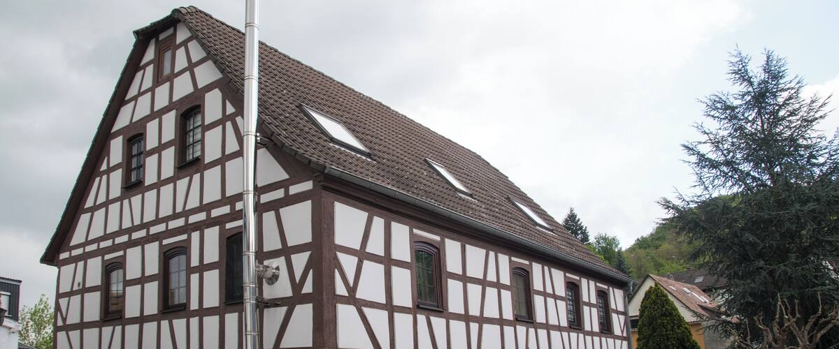 A traditional half-timbered house with a sloped roof and dormer windows.
