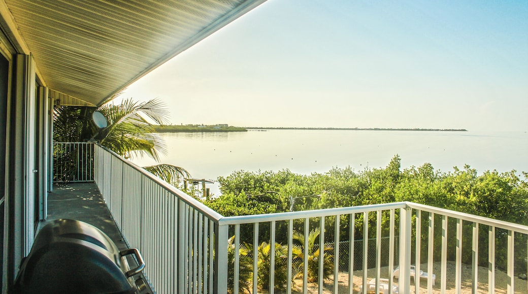 Looking out over tropical ocean from balcony of vacation rental over private beach with grill and TV satellite - Horizon is thin line