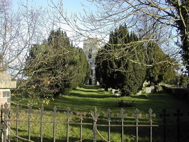 St James the Great parish churchyard, Saul, Gloucestershire, with the west tower of the church showing between the yews