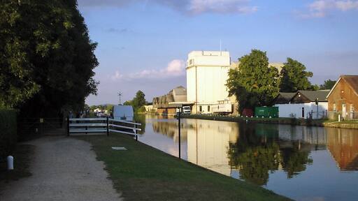 G&S Canal and former Cadbury's factory. Cadbury's opened a factory adjacent to the Gloucester & Sharpness canal near Fretherne Bridge in 1916. The factory produced chocolate crumb from ground cocoa beans, sugar, and milk from local farms before being transported to the Bournville factory in Birmingham by narrowboat. The silo in the centre of the picture was added later to provide additional storage. The factory is now occupied by several businesses including Shipton Mill.