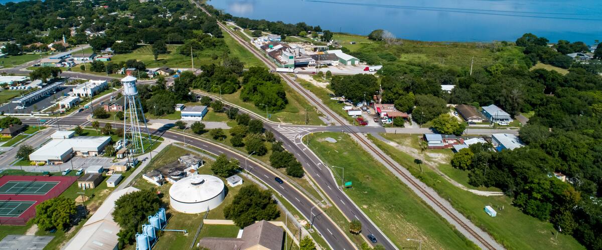 An aerial view of a town with a large lake, roads, and industrial buildings.
