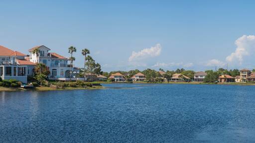 Four Prong lake views of villas at Destin, Florida. Panorama of large single-family homes with green field and trees outdoors against the sky background.