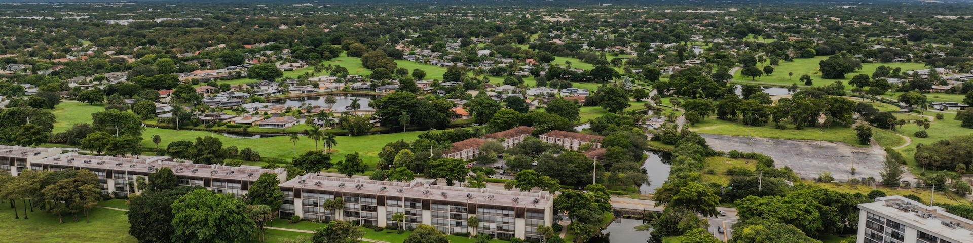 Aerial view of a suburban landscape with lush greenery under a cloudy sky. Lauderhill, Florida