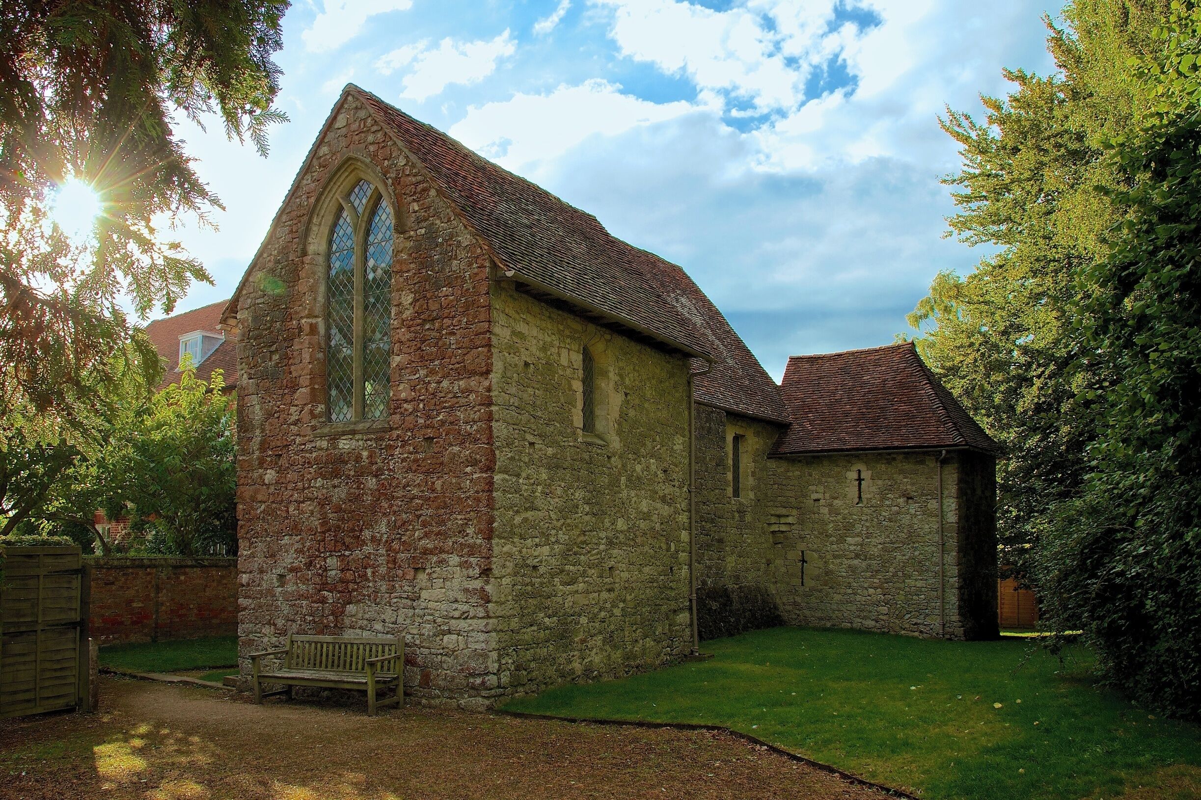 A stone church with a pointed arch window and a smaller attached building.