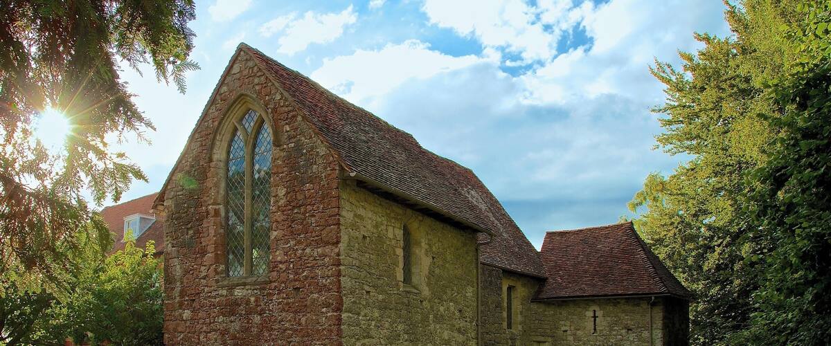 A stone church with a pointed arch window and a smaller attached building.