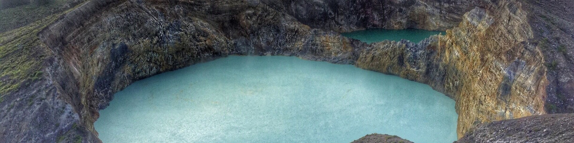 Tri-color crater lakes of Mount Kelimutu in Moni, Flores. Third crater's behind me. These two change color every once in a while and it's always unpredictable. In the past, they've turned pink, white, black, blood red, brown, and yellow.