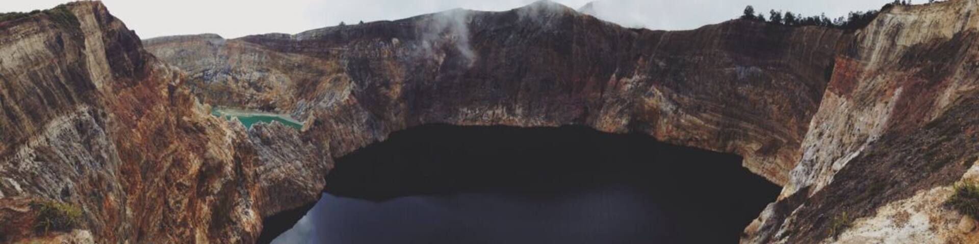 A large crater lake surrounded by steep, rugged cliffs.