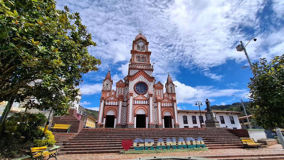 A church with a clock tower and a sign reading "Granada".