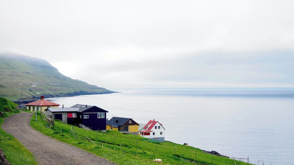 Une route côtière bordée de maisons, avec vue sur la mer.
