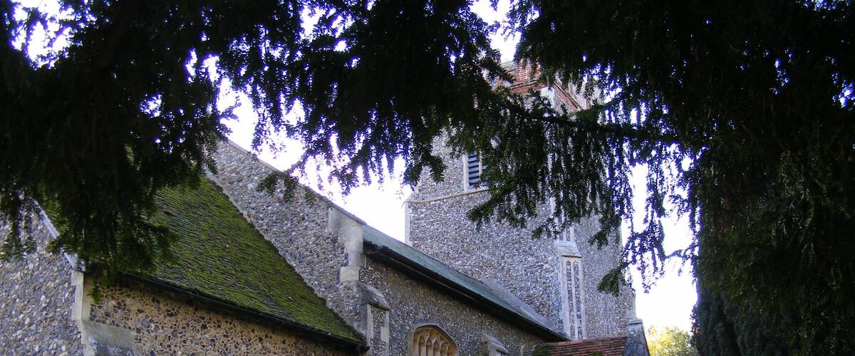 A historic stone church with arched windows and a stone wall.