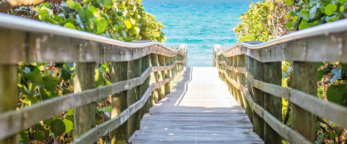 Wooden pier leading out to beautiful beach.