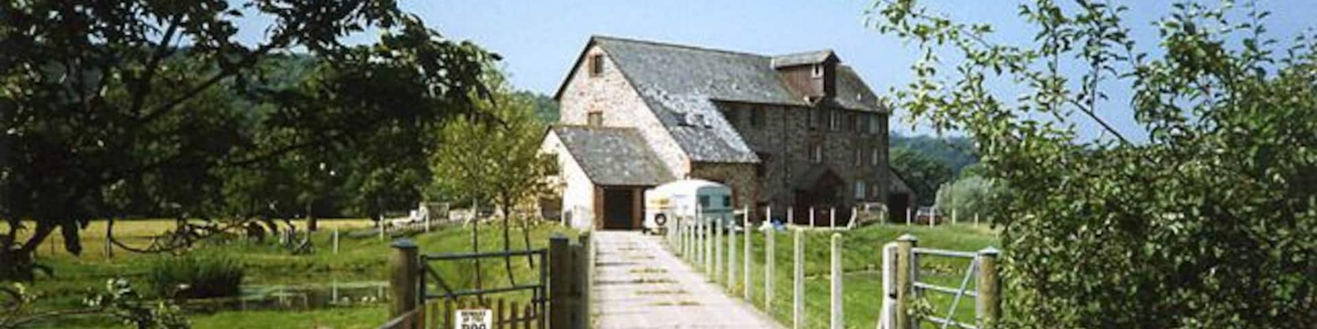 Weare Giffard: Wear Mills. On a leat by the river Torridge; in the 18th and 19th century barges would bring grain on the top of the tide from Bideford. By 1889 the mill was fitted with a turbine and roller milling machinery by Henry Simon of Manchester; the turbine was appropriate as the Torridge is liable to flood. The mill has been converted to a private residence