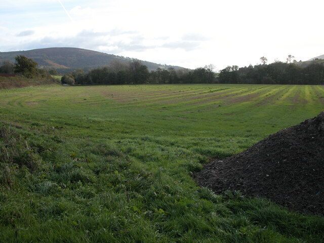 Farmland at Kentchurch The line of trees on the far side of the field indicates the route of the river Monnow which is also the boundary between England and wales. Wales is on the opposite side of the river. The hill in the background is Garway Hill.