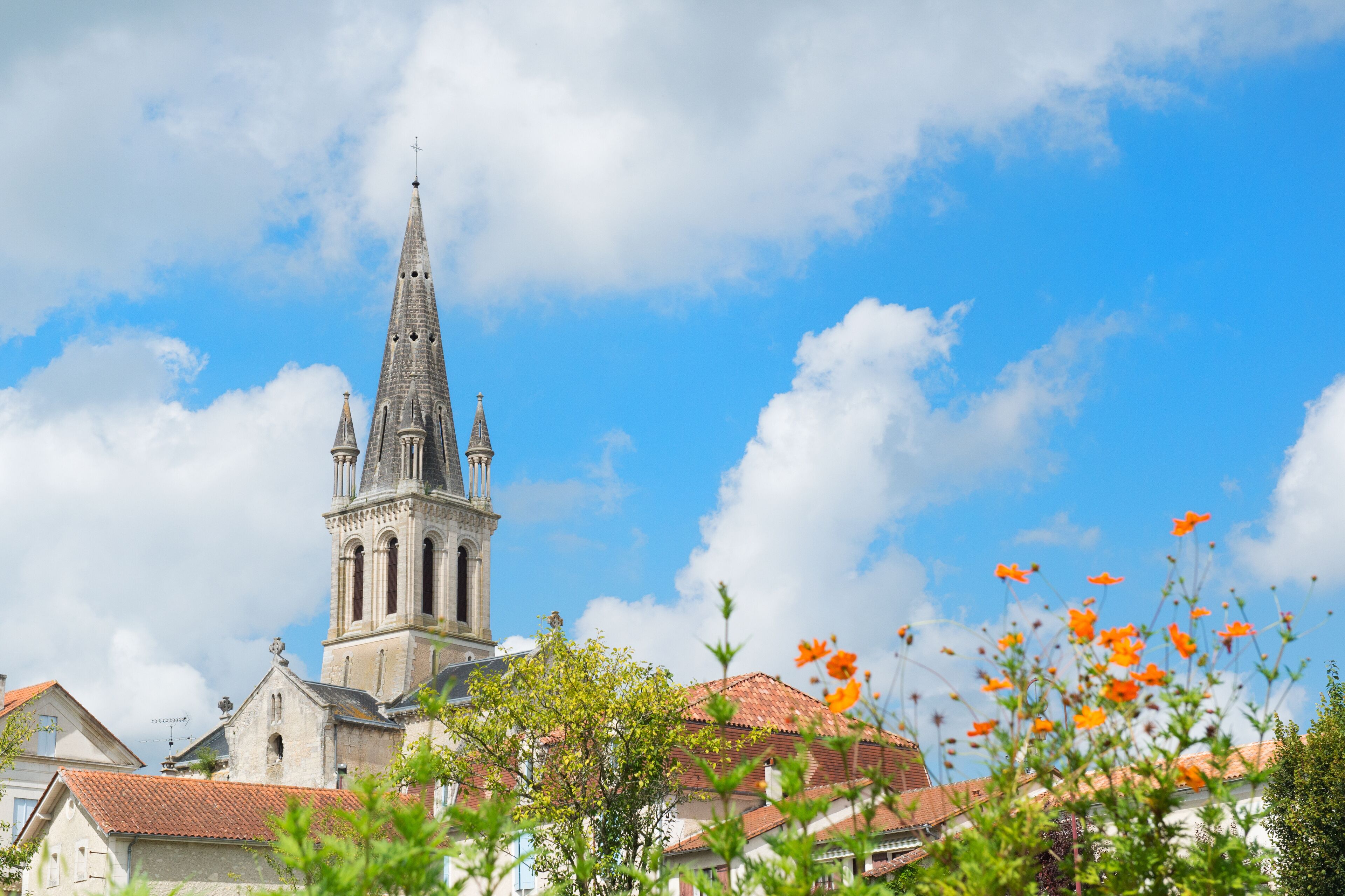 A church with a tall spire and a red-tiled roof.