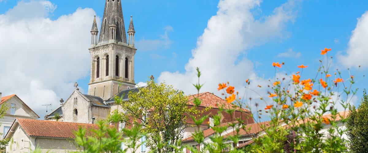 A church with a tall spire and a red-tiled roof.