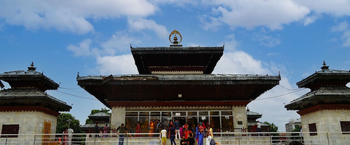 A traditional temple with a large central building and two smaller structures on either side.