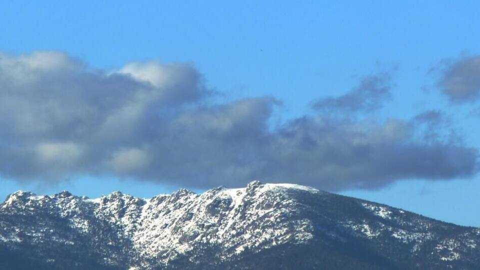 Snow-covered mountains under a clear blue sky.