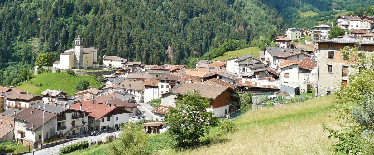 A mountainous village with a church and residential buildings.
