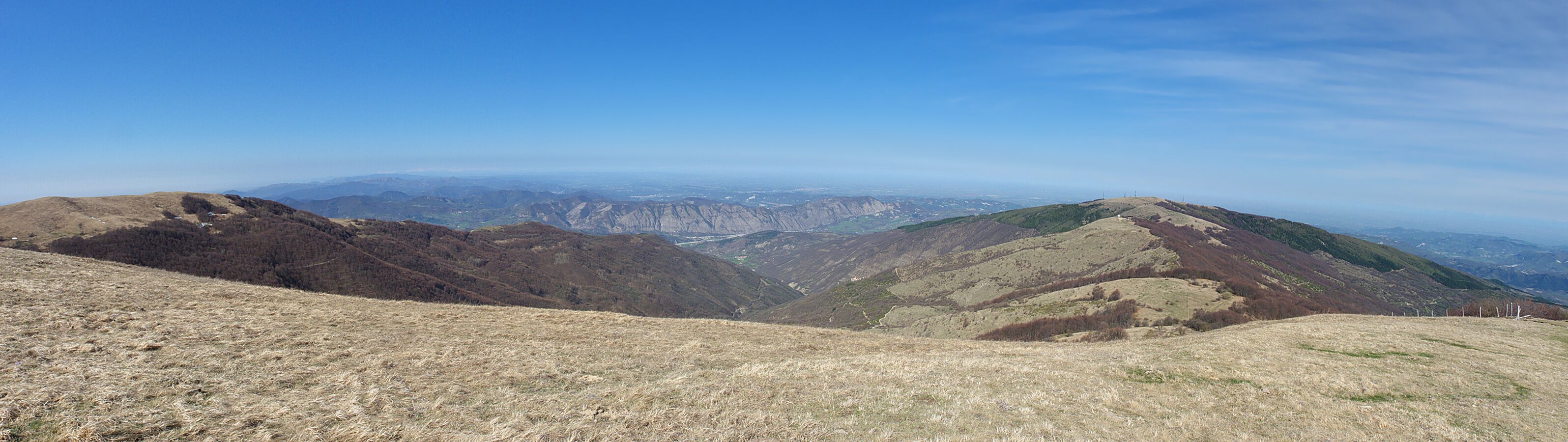 A mountainous landscape with dry grass and rocky terrain.
