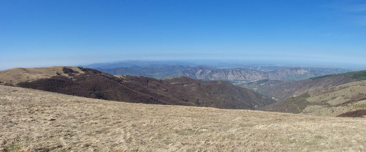 A mountainous landscape with dry grass and rocky terrain.