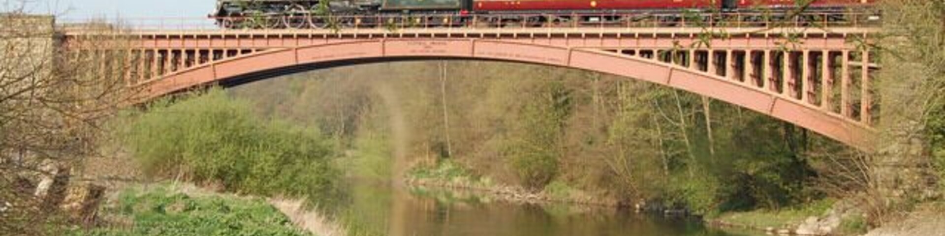 Um trem atravessando uma ponte sobre um rio.