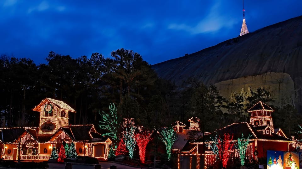 A town illuminated with colorful lights, including houses and trees.