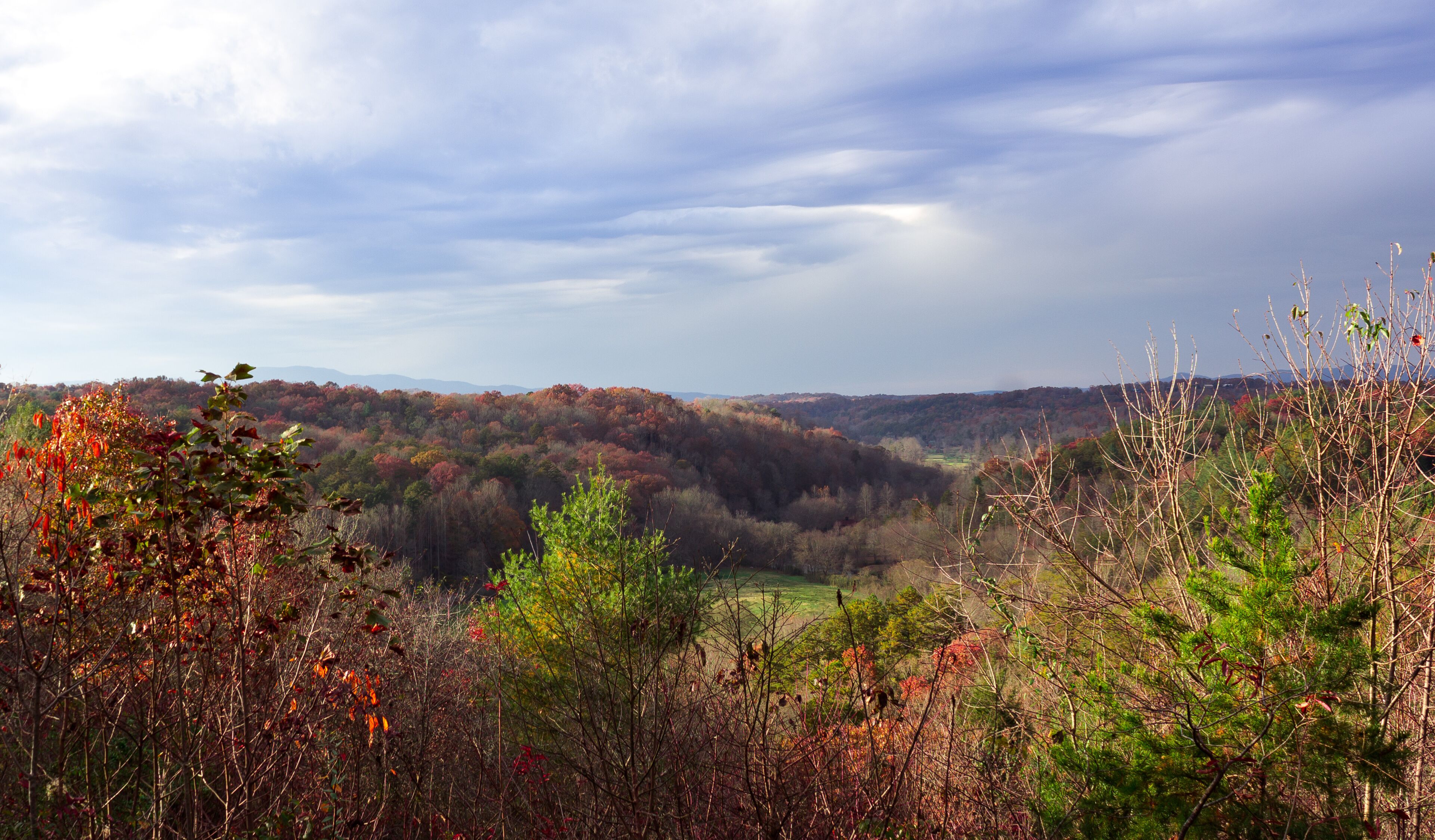 Landscape view of a house in Blue Ridge Georgia, USA surrounded by red and orange landscape at the end of Fall.