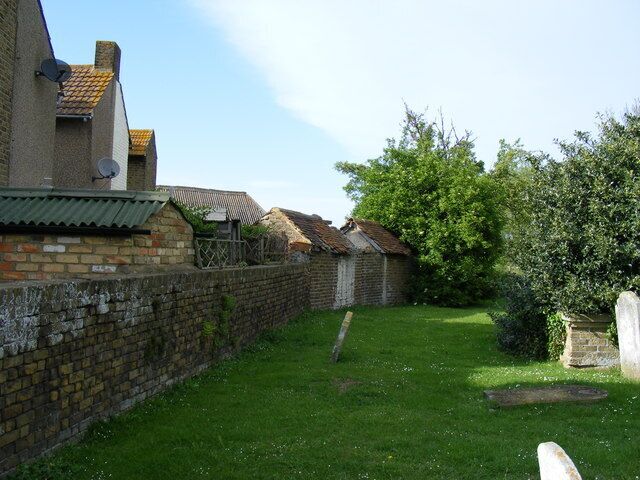 Churchyard and rear of houses in The Street Iwade The small buildings on the left of the picture are (I assume) outside toilets.