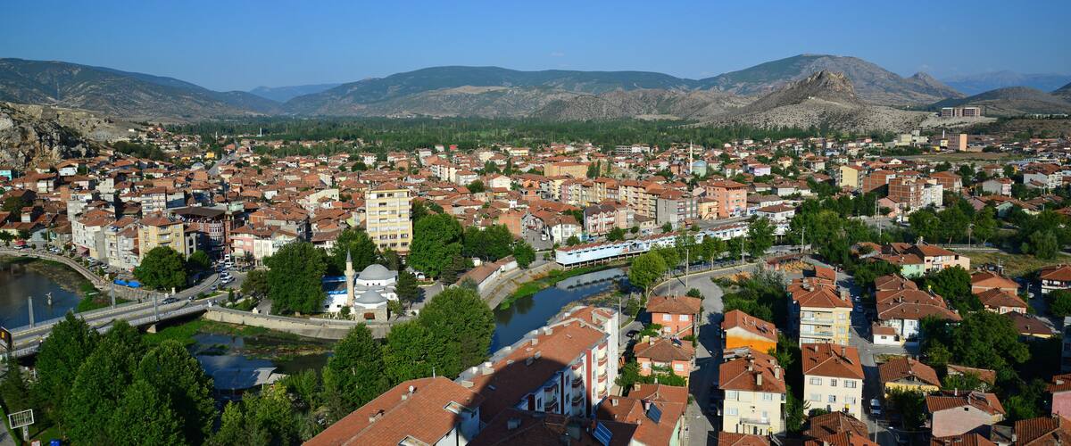 A town with a river, mountains, and a bridge.