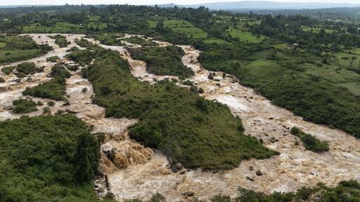 Aerial view of the Nzoia River's muddy waters carving through lush green landscapes, a symphony of earthy tones and verdant life, Webuye, Bungoma County, Kenya.