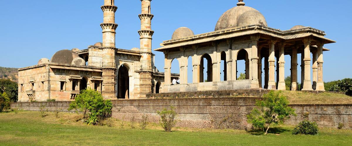 An ancient structure with domes, minarets, and arched columns.