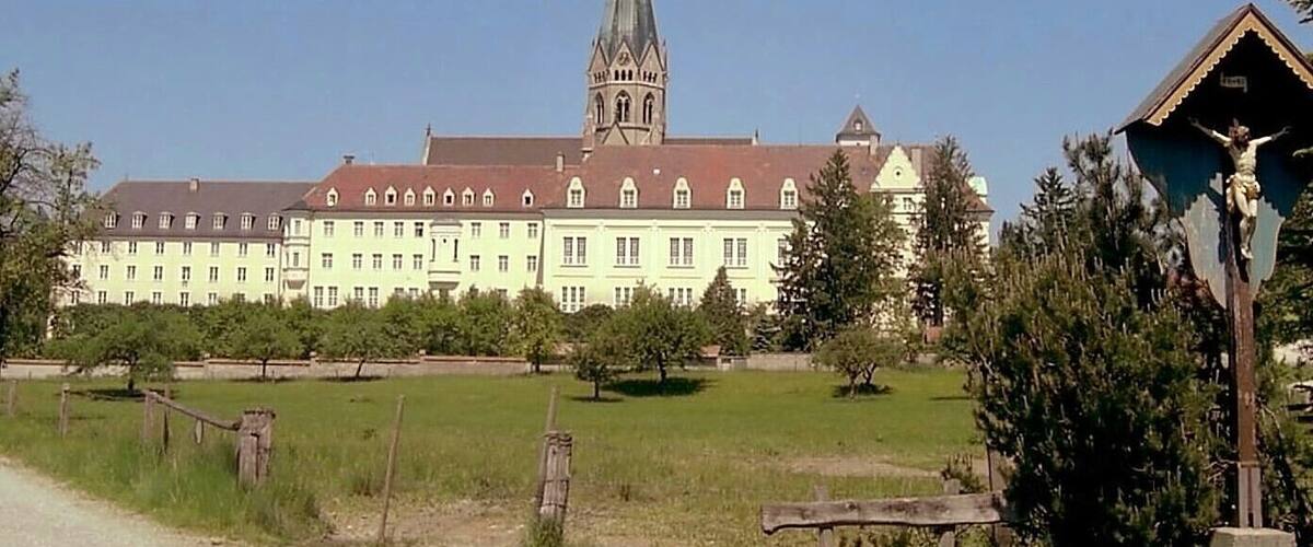A large building with a prominent tower and a statue of Jesus Christ.