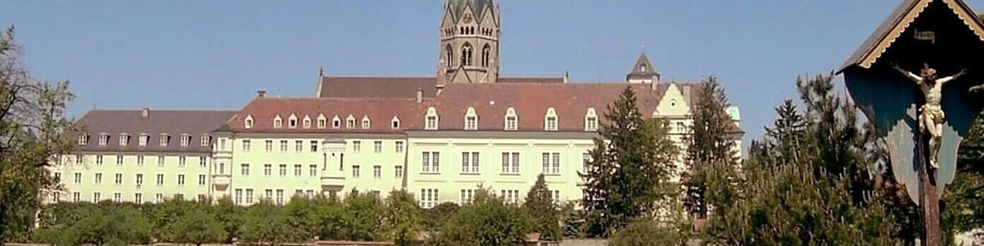 A large building with a prominent tower and a statue of Jesus Christ.