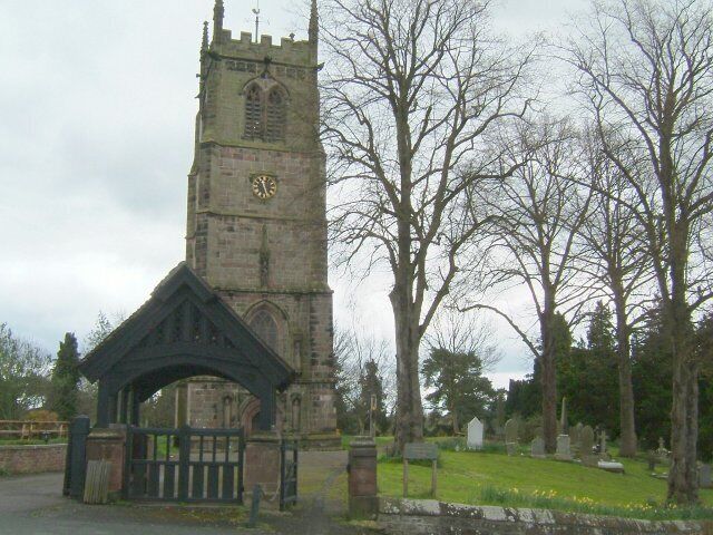 A church with a tall tower and a gate.