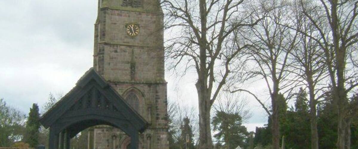 A church with a tall tower and a gate.