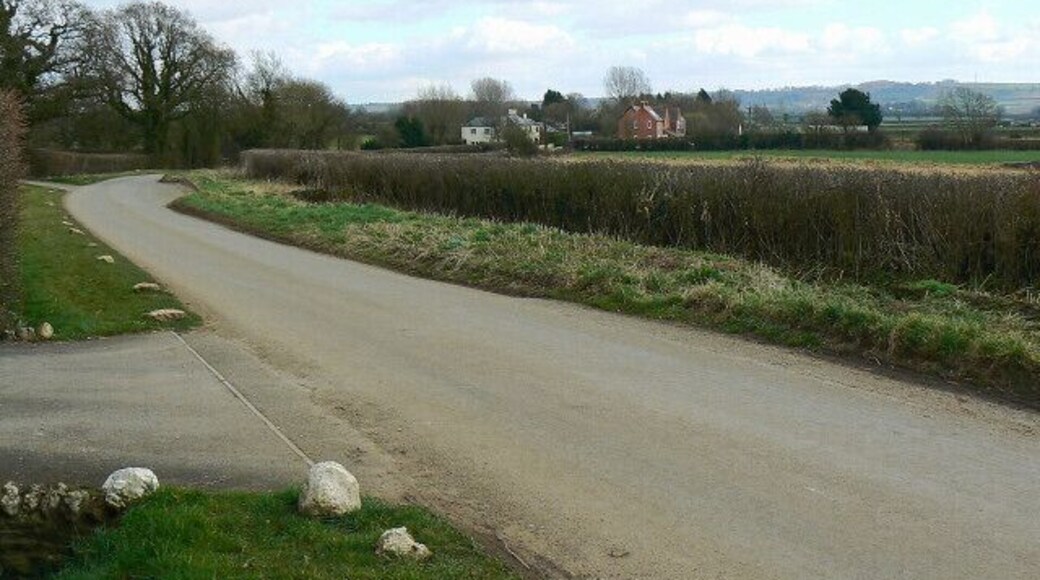 The road to Bushton The maps show the road is known as 'The Greenway'. The properties in the background straddle the southern gridline of this square.