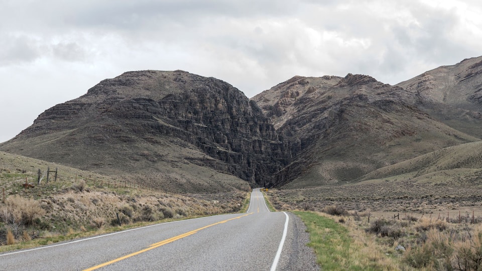 A road leading through a mountainous landscape with sparse vegetation.