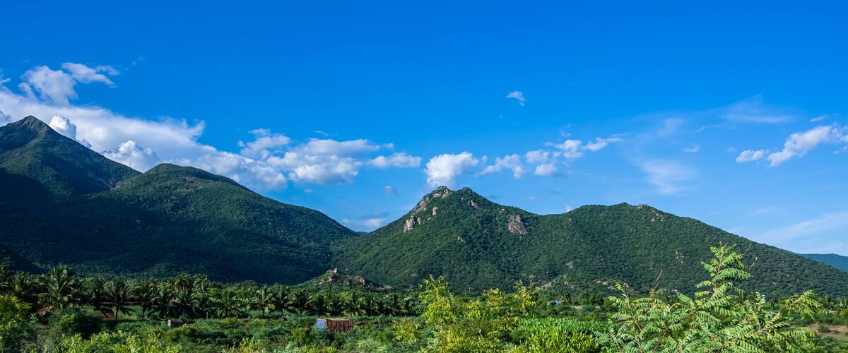 A mountainous landscape with lush greenery and a clear blue sky.
