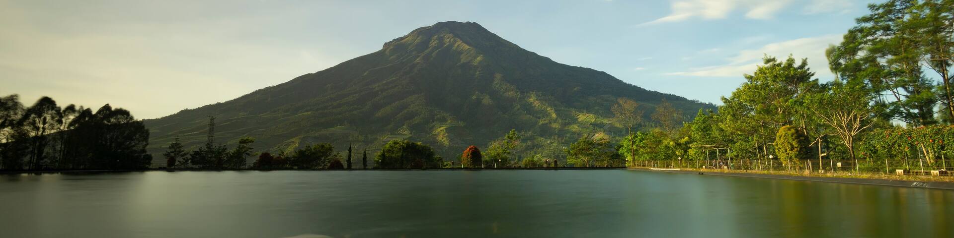 landscape view of mount sumbing sindoro in embung kledung temanggung central java indonesia with an artificial lake and swimming fish suitable for background wallpaper notes and design