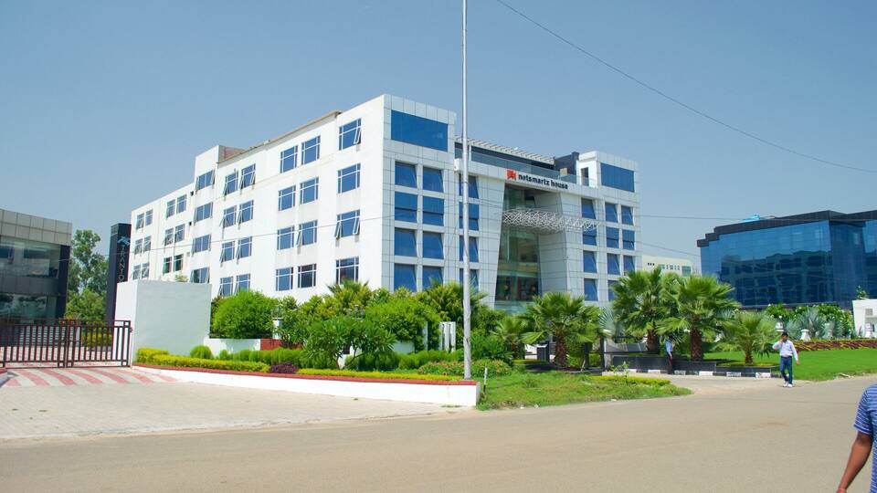A modern building with a sign reading "Heimsartz House" and a clear blue sky.