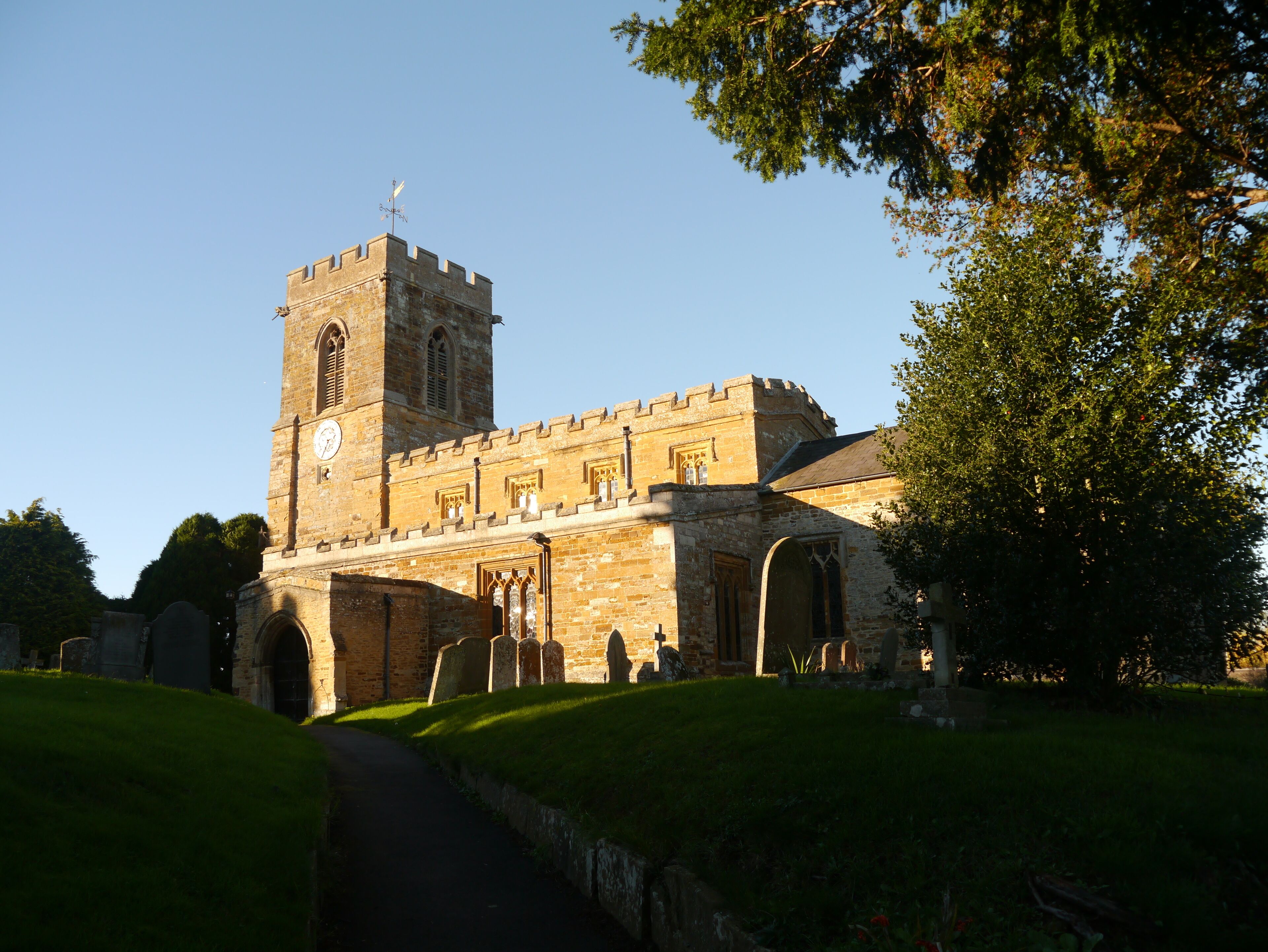 A historic stone church with a tall bell tower and arched windows.