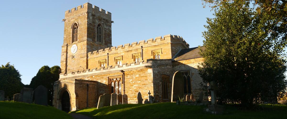 A historic stone church with a tall bell tower and arched windows.