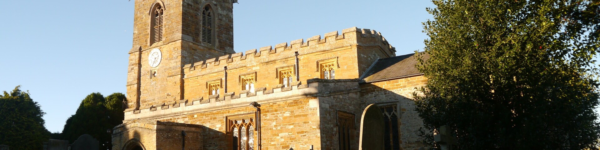 A historic stone church with a tall bell tower and arched windows.