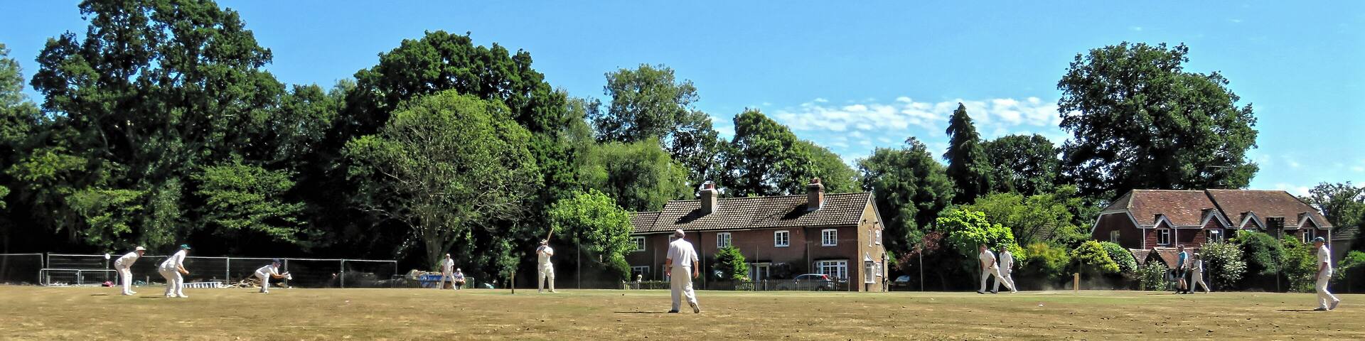 A public friendly Sunday cricket match between Nuthurst Cricket Club (batting), representing Nuthurst parish, and Henfield Cricket Club representing Henfield parish, on the village green cricket ground at Mannings Heath in West Sussex, England. Camera: Canon PowerShot SX60 HS Software: File lens-corrected, optimized, perhaps cropped, with DxO PhotoLab , and likely further optimized with Adobe Photoshop CS2.